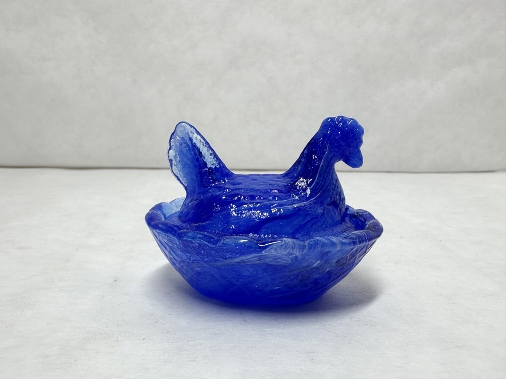 COBALT BLUE SLAG GLASS HEN ON NEST: A two-piece slag glass covered dish featuring a cobalt blue base color with white and light blue marbleized swirls throughout. The lid is molded in the form of a seated hen with a fanned tail, and the