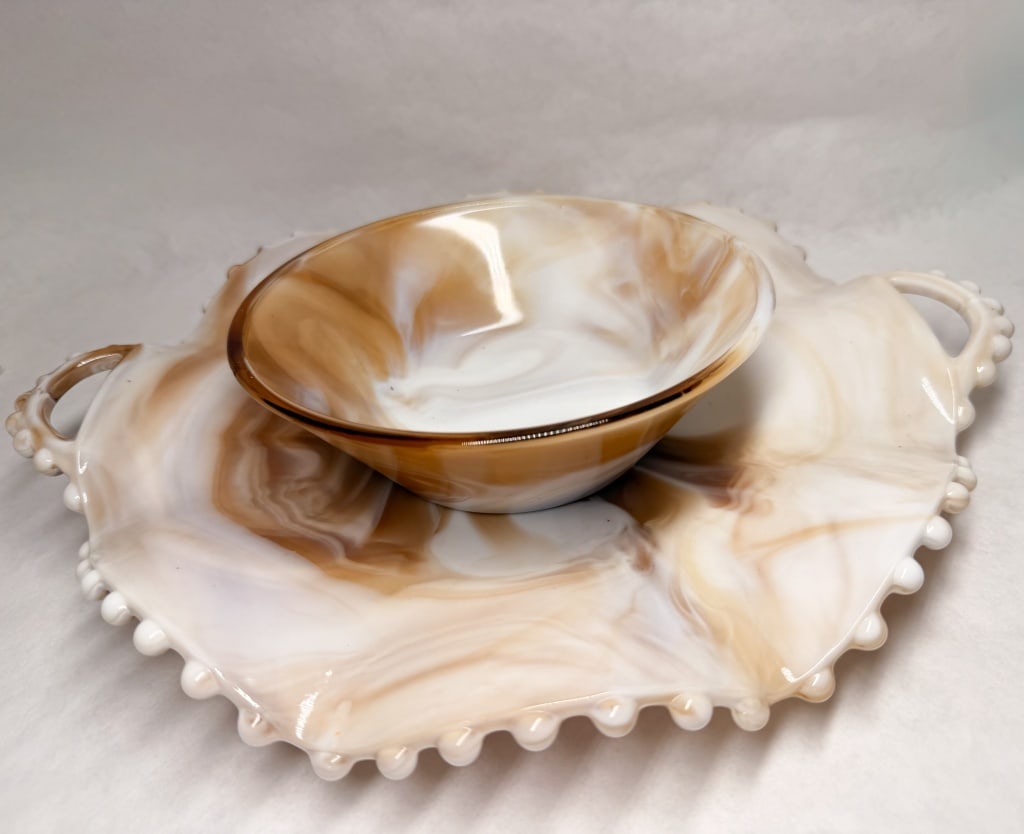 CARAMEL SLAG GLASS SERVING SET, VINTAGE: A two-piece vintage caramel slag glass serving set comprising a handled tray with a ruffled, beaded rim and a matching circular flared bowl. No maker's marks or stamps are visible on the base of eithe