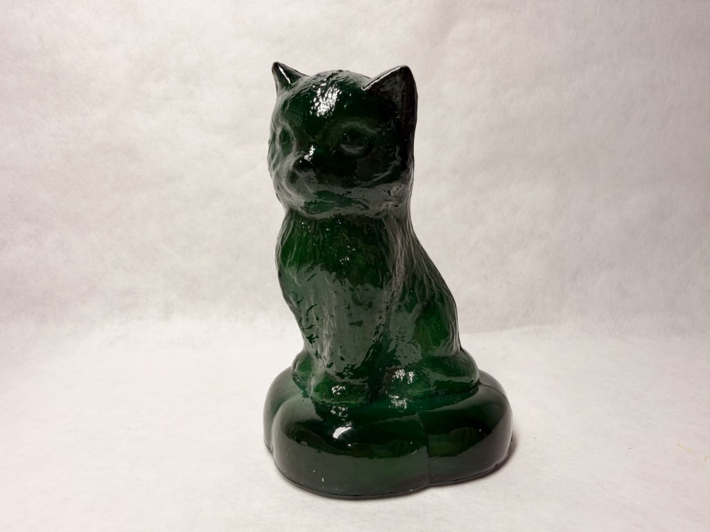 BOYD GREEN GLASS SITTING KITTEN PILLOW 1978-1983: Dark green pressed glass seated cat figurine produced by Boyd Art Glass. A molded monogram consisting of a capital B within a diamond is located on the reverse of the base (photo 5).