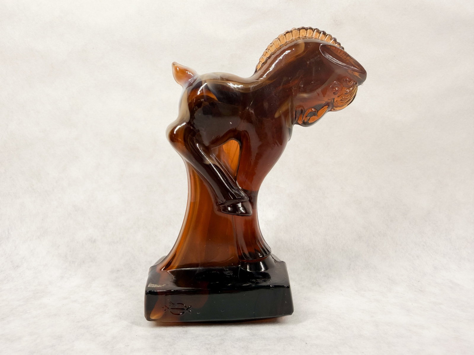 IMPERIAL CHOCOLATE SLAG GLASS COLT: A chocolate slag glass figurine depicting a stylized colt in a rearing pose. The front of the rectangular pedestal base is embossed with a monogram consisting of a capital letter I superimposed over
