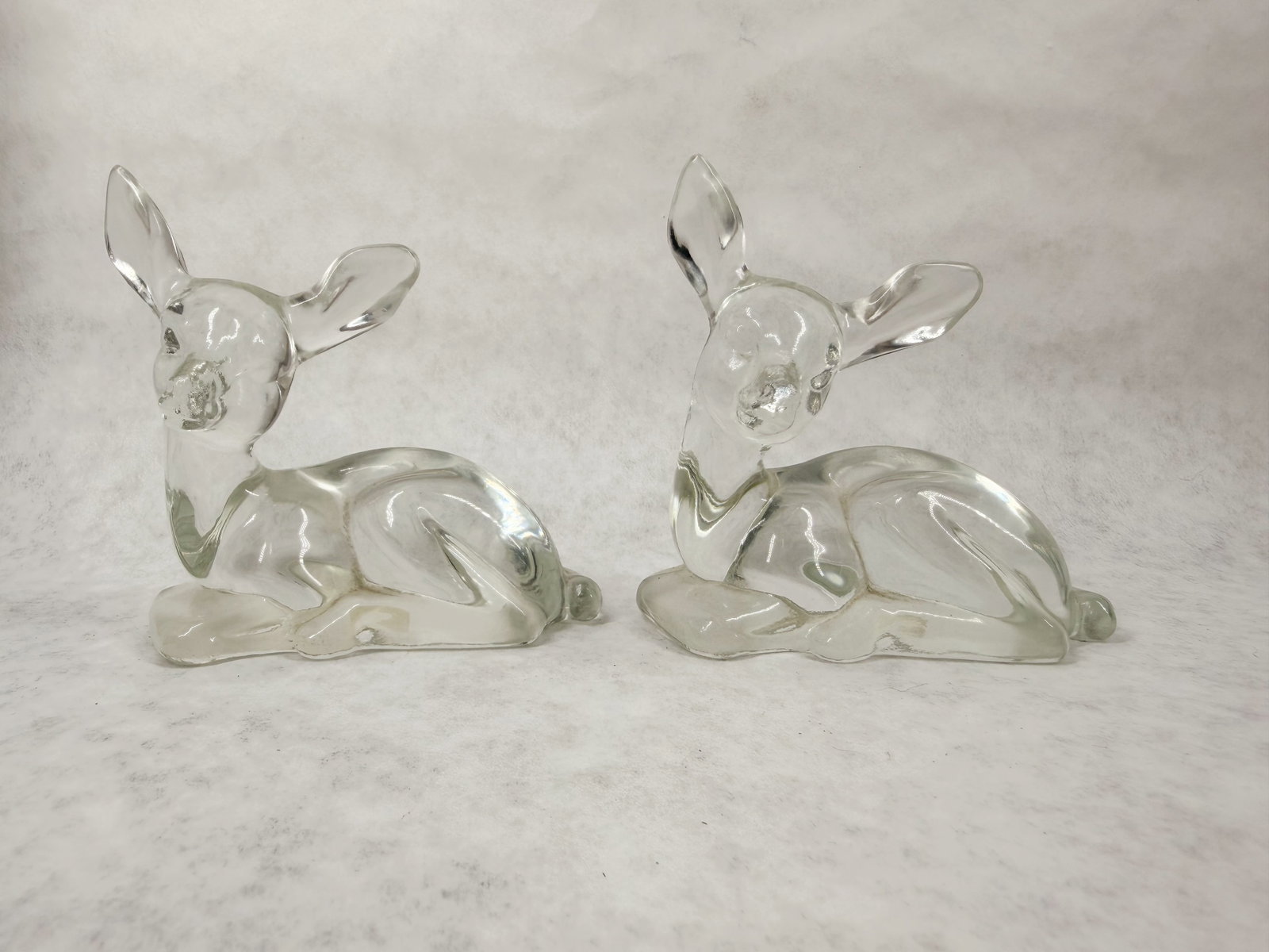 FENTON CRYSTAL FAWNS (2): An American collection of glass animal figurines featuring a pair of mirrored clear fawns produced by the Fenton Art Glass Company with embossed oval script marks and original labels on the base.