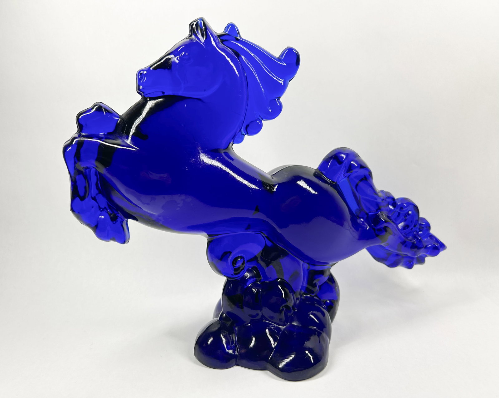 HCA COBALT BLUE FLYING MARE, 1989: Cobalt blue pressed glass figurine depicting a rearing horse, known as the Flying Mare. An embossed mark on the circular base consists of the numeral 9 positioned above the letters HCA (photo 3).