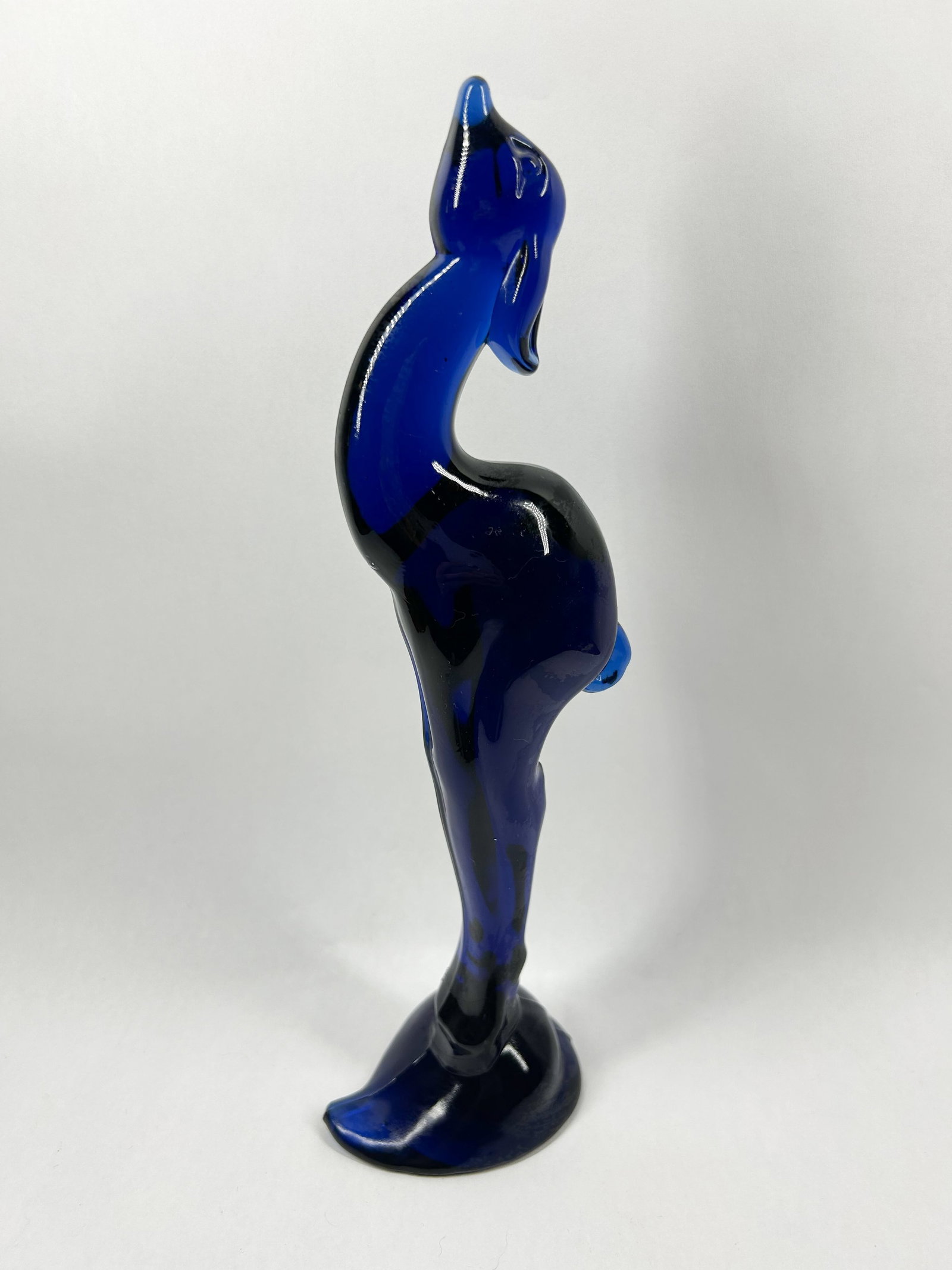 HEISEY BY IMPERIAL GAZELLE ULTRA BLUE: Stylized art glass figurine of a gazelle crafted in translucent cobalt blue with internal dark streaks. Minimalist design features an elongated neck and body supported by a single leg on a flared