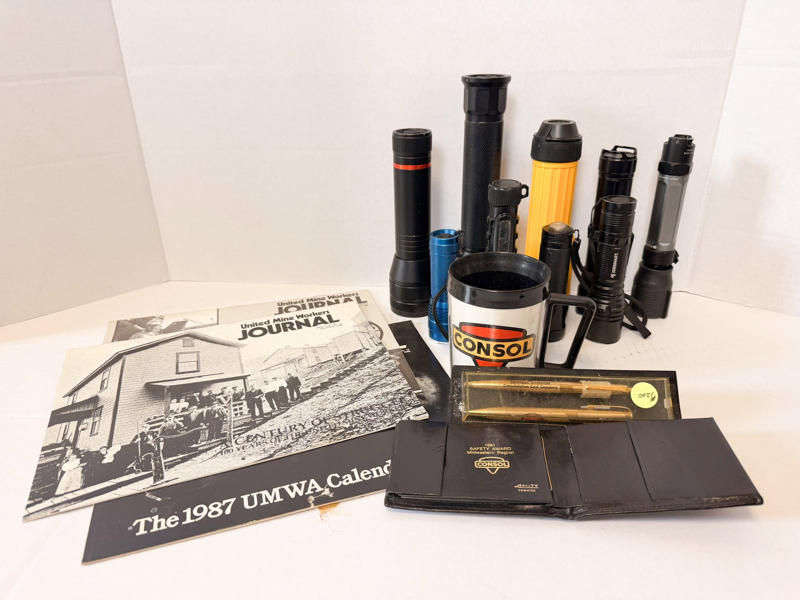 CONSOL AND UMWA MINING MEMORABILIA, 1980S: A collection of United Mine Workers of America and Consolidation Coal Company memorabilia featuring a 1981 Amity cowhide safety award wallet and a boxed gold-tone pen set marked CENTRAL DIVISION