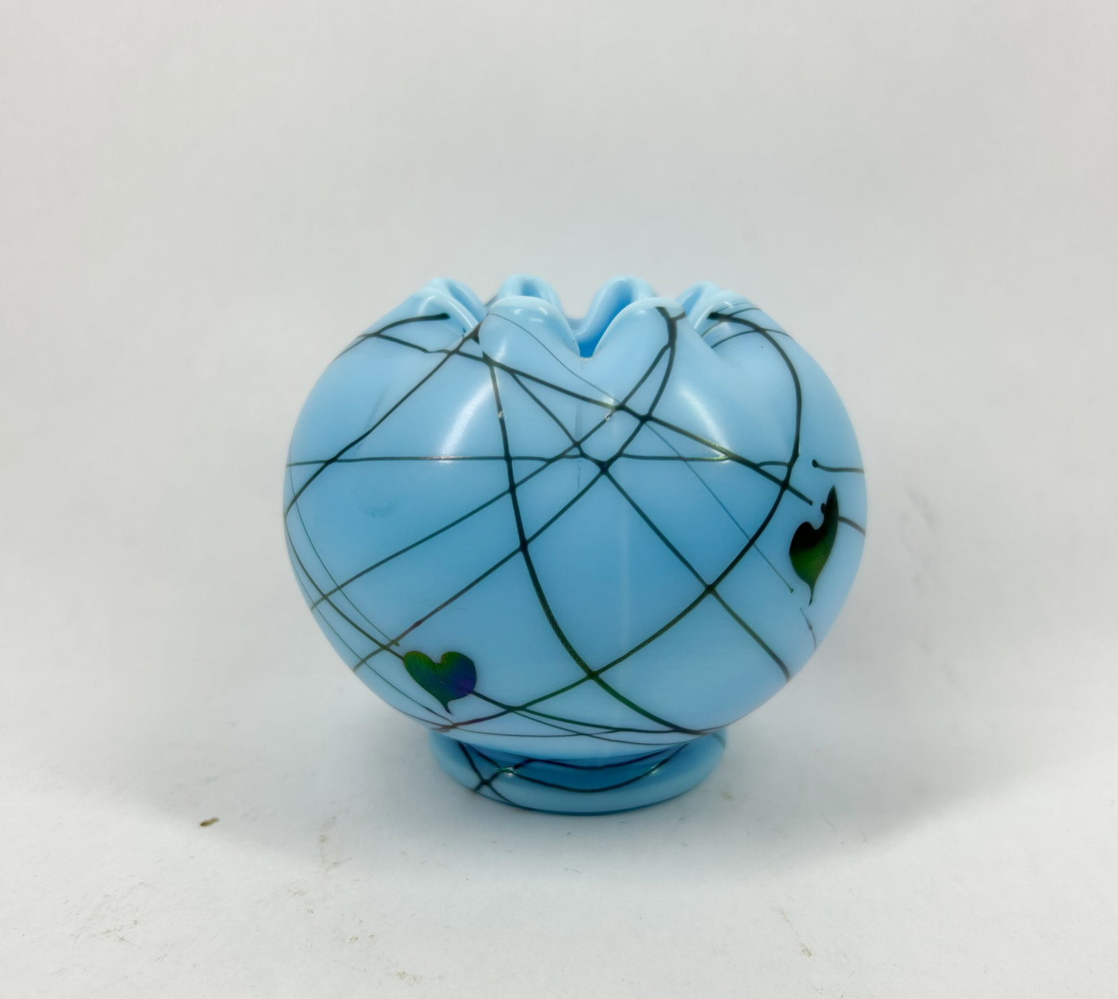 TURQUOISE HANGING HEARTS GLASS ROSE BOWL FENTON: Turquoise art glass rose bowl decorated with iridescent hanging heart motifs and dark trailed glass vines. The vessel features a bulbous body with a heavily crimped rim and sits on a short integral fo