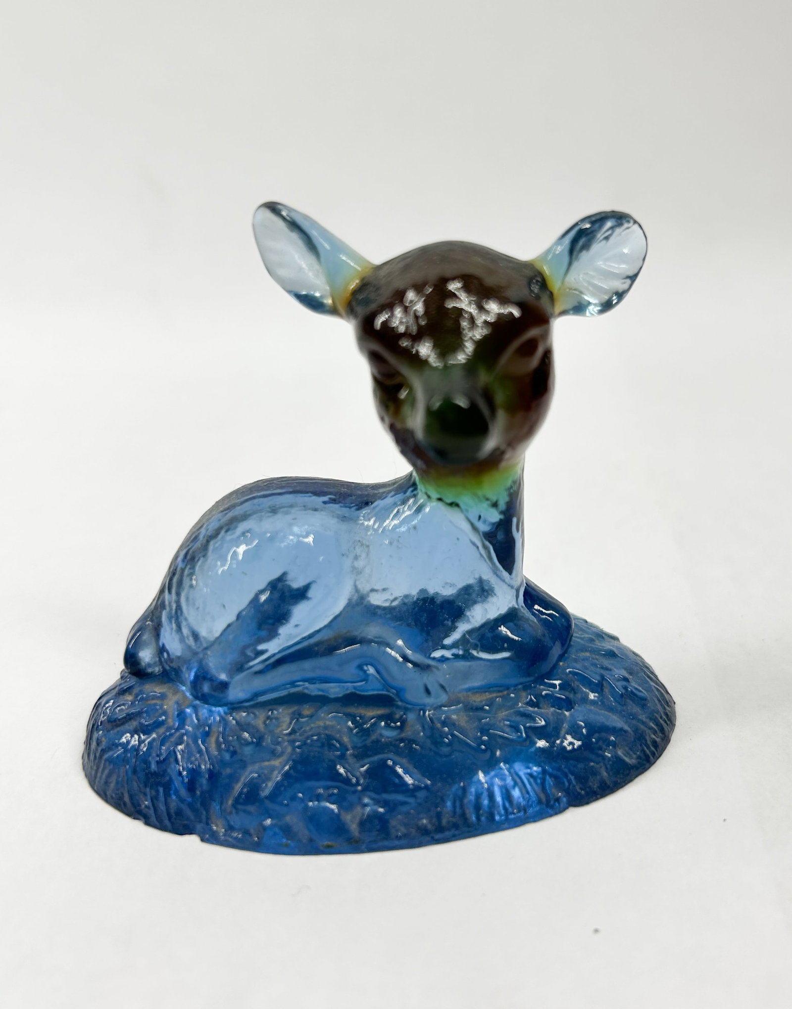 BOYD MULTICOLOR BINGO DEER: A reclining fawn figurine crafted from bicolor translucent blue and dark brown molded art glass. The figure features stylized white forehead spots and a textured oval base; no maker's marks,