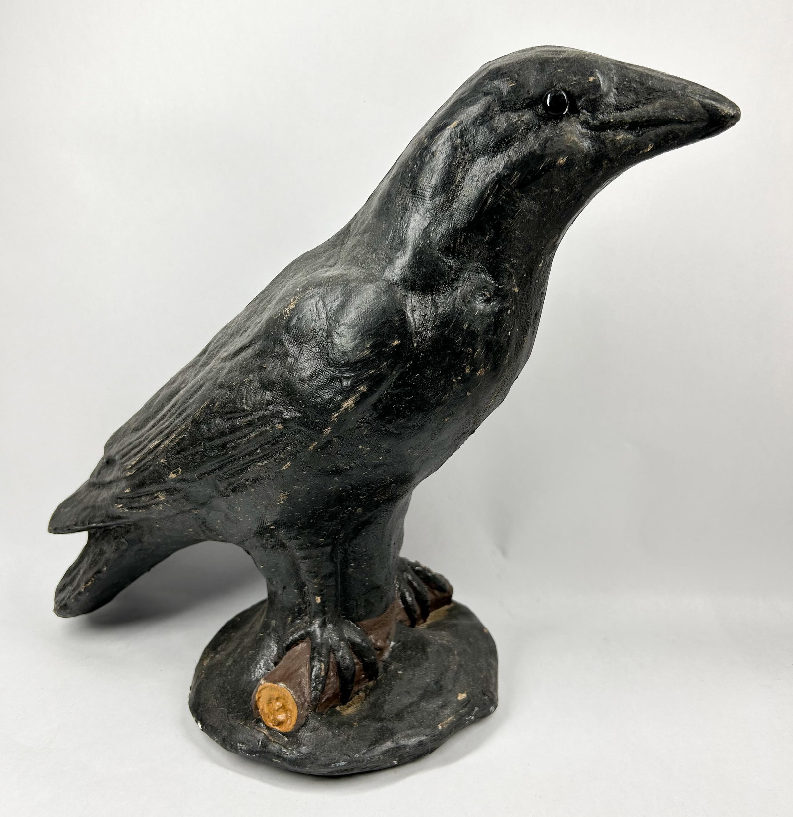CHALKWARE CROW FIGURINE, VINTAGE: A vintage folk art style figurine of a crow or raven perched on a branch. The piece is constructed of chalkware with a textured matte black painted finish and an inset glossy black bead eye.