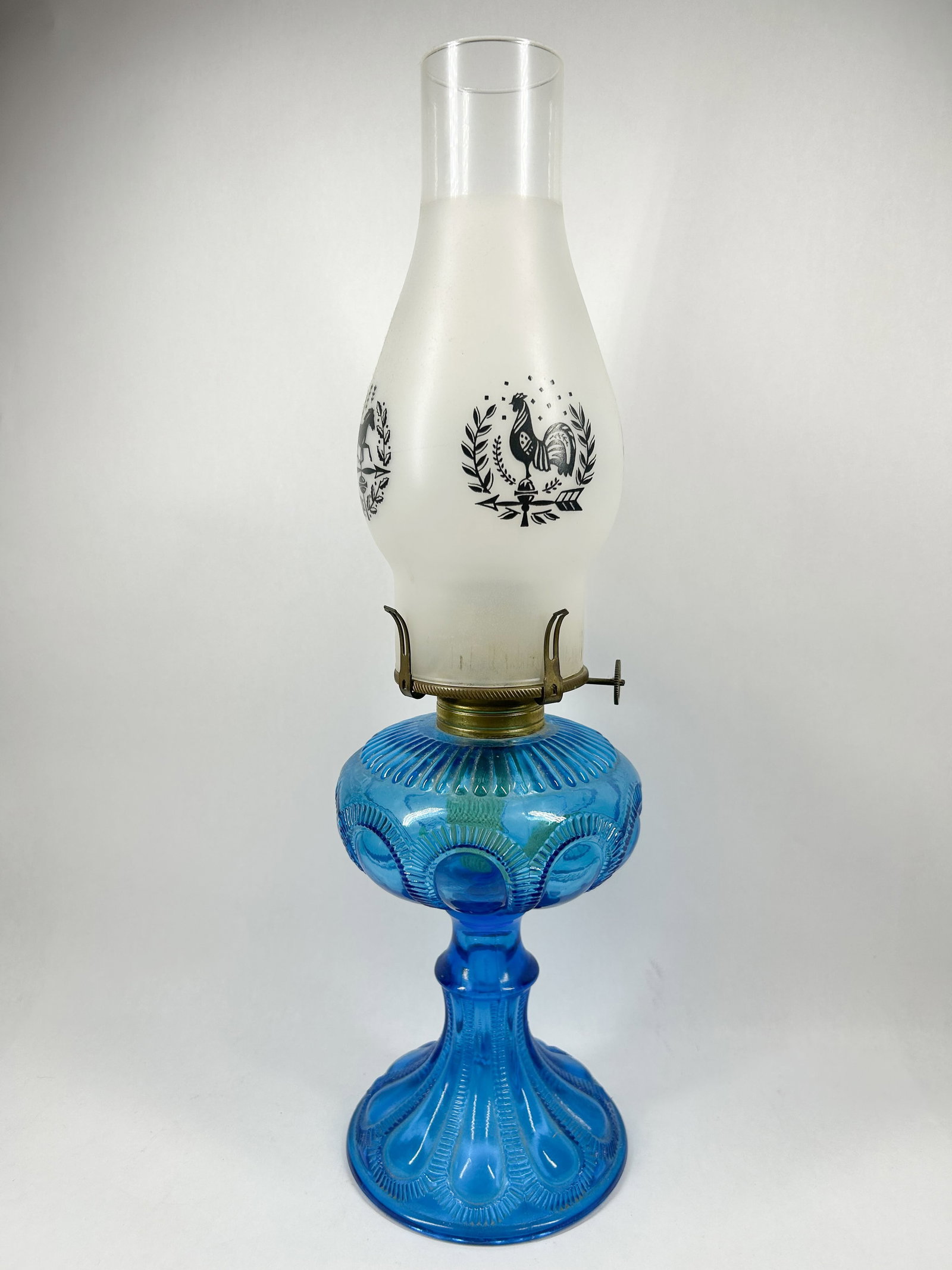 EAGLE BLUE GLASS LAMP, VINTAGE: Eagle vintage blue glass Moon and Star oil lamp featuring a burner thumbwheel stamped EAGLE in an arc with illegible text below. The frosted glass chimney is decorated with transfer-printed