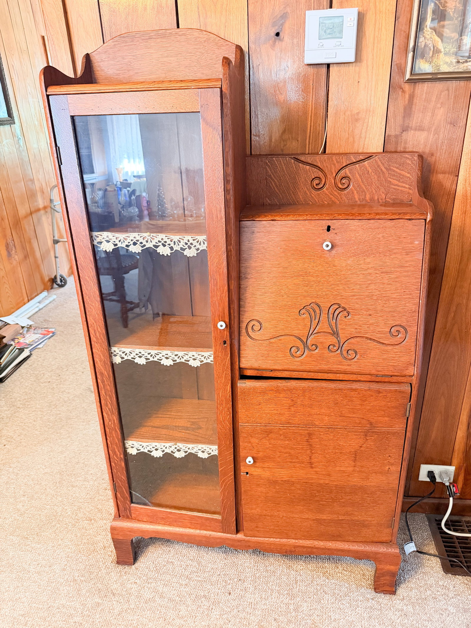 AMERICAN OAK SIDE-BY-SIDE SECRETARY, CIRCA 1900: An American oak side-by-side secretary bookcase featuring a glazed display door and a drop-front writing desk. The unit includes a fitted interior with pigeonholes and a central drawer, decorated