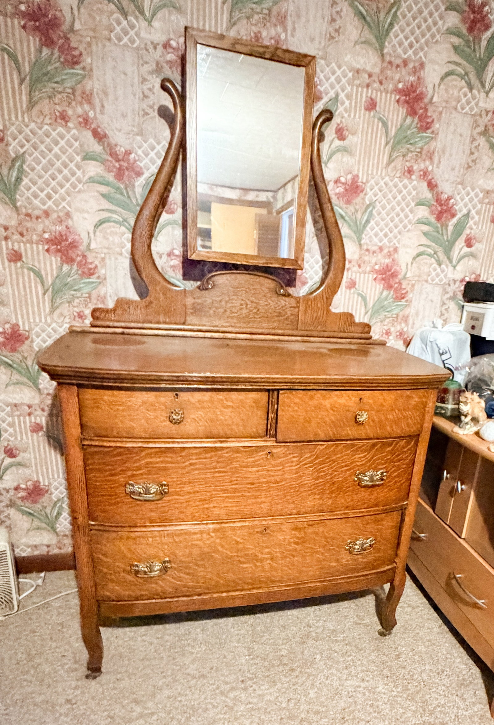AMERICAN QUARTERSAWN OAK SERPENTINE DRESSER: An American quartersawn oak chest of drawers featuring a serpentine front and wishbone mirror assembly. The piece is constructed with tiger oak veneers and fitted with ornate brass-plated hardware and
