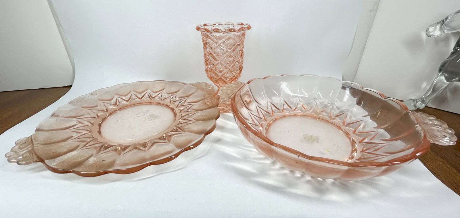 VIKING GLASS, TRIO OF PINK GLASSWARE, C.1950S: Viking Glass trio of pink handmade glassware comprising a handled tray, a matching bowl, and a quilted pedestal vase. The bowl bears a white rectangular adhesive label featuring a stylized Viking long
