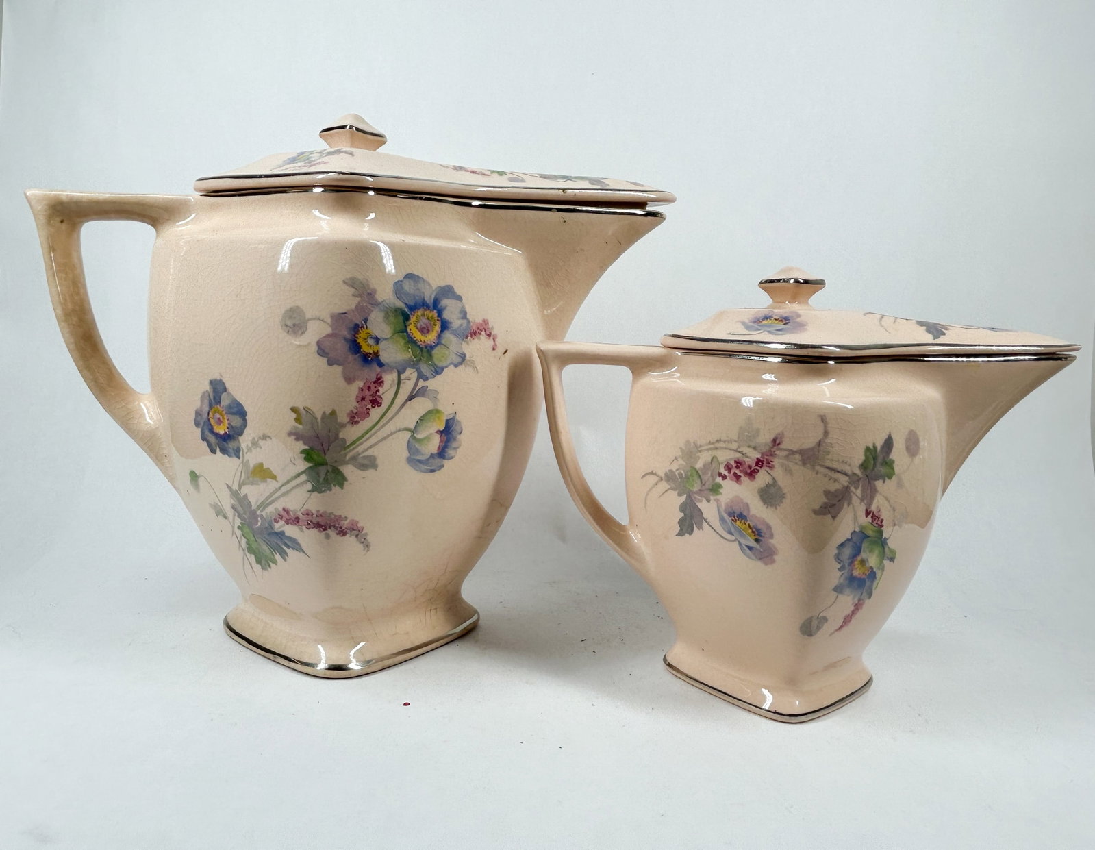 CROOKSVILLE PANTRY BAK-IN PITCHERS, CIRCA 1930: A pair of lidded cream-colored earthenware pitchers produced by the Crooksville China Company, each bearing a reddish-orange printed mark on the base reading "PANTRY BAK-IN by WARE Crooksville".