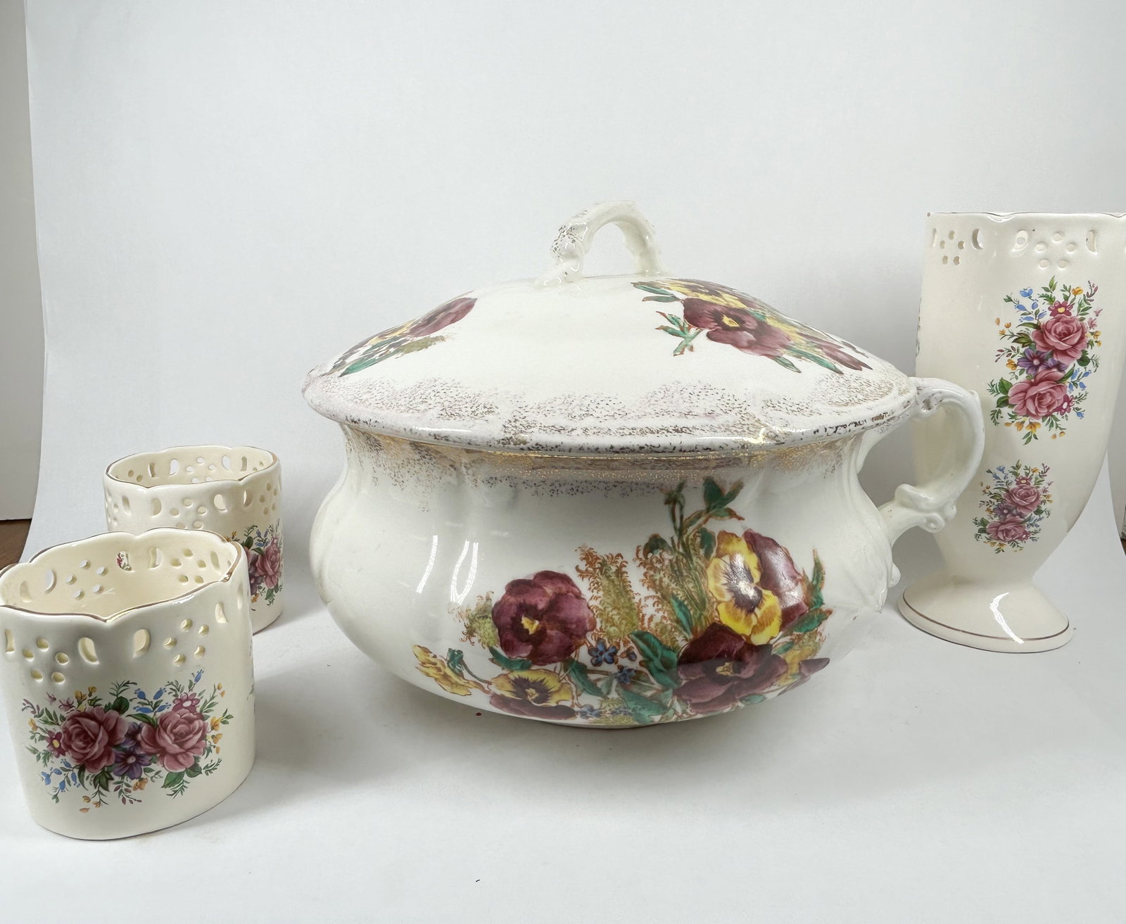 BAUM BROS. CERAMIC FLORAL COMMODE SET: A ceramic washstand set by Baum Bros. in the Formalities pattern. The pieces feature transfer-printed floral designs including pansies and roses, complemented by gold-toned sponged gilding on the