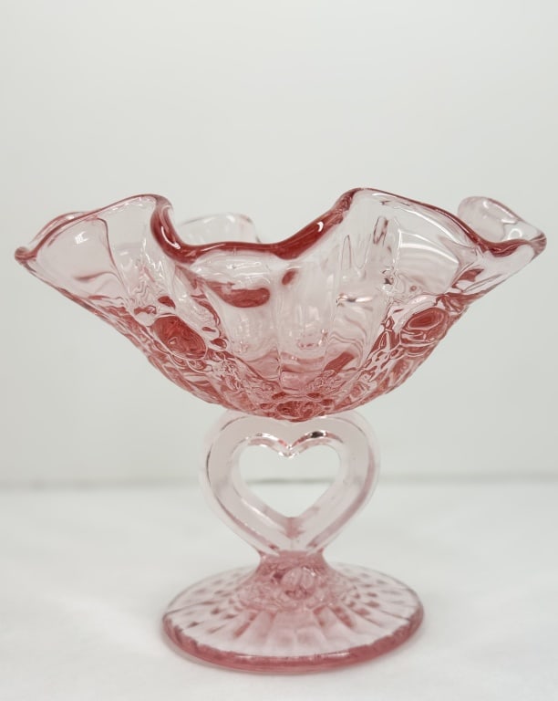 FENTON PINK CABBAGE ROSE COMPOTE, 1990S: A pink pressed glass compote by the Fenton Art Glass Company in the Cabbage Rose pattern, featuring a ruffled rim and a heart-shaped stem. The base bears an embossed mark within a recessed oval readin