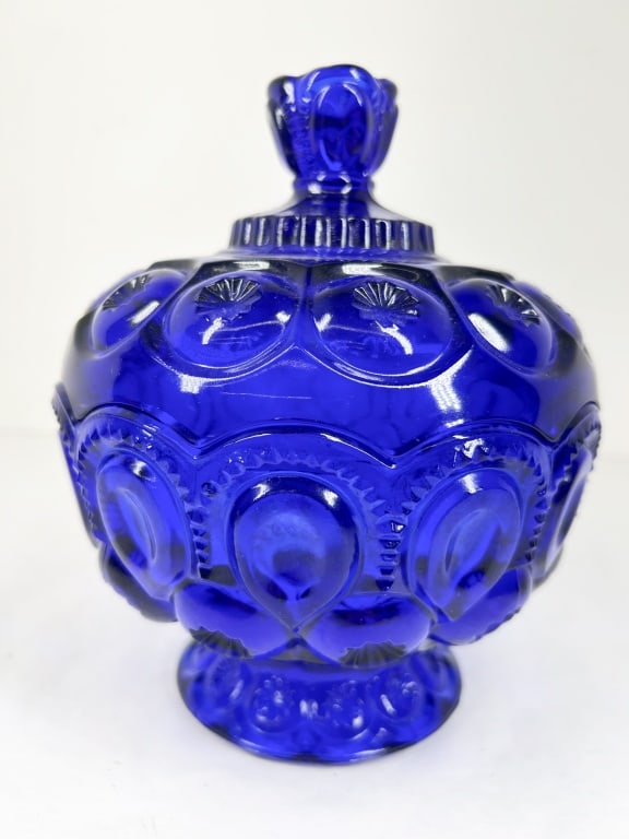 COBALT BLUE MOON AND STAR COMPOTE: A pressed cobalt blue glass lidded candy dish in the Moon and Star pattern. The interior base is embossed with the characters M & S, identifying the piece as part of the Moon and Star collection produ