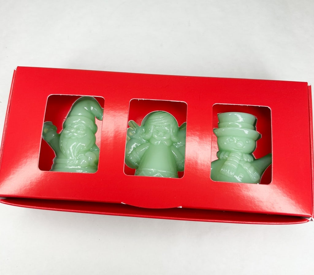 MOSSER TRIO OF JADEITE GLASS HOLIDAY SET: A trio of Christmas-themed figurines comprising a Santa Claus, an angel, and a snowman, all cast in opaque seafoam green jadeite glass. Each piece features molded relief details and is presented in a 