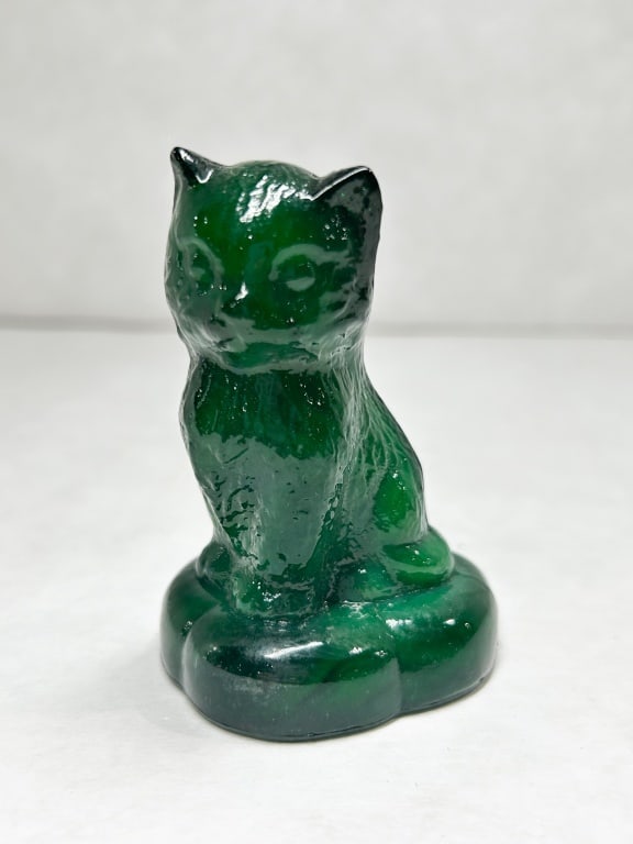 BOYD EMERALD SLAG SITTING KITTEN ON PILLOW: A molded slag glass figurine of a seated kitten with textured fur details. The base features an embossed diamond containing a stylized letter B, representing Boyd's Crystal Art Glass, and the material