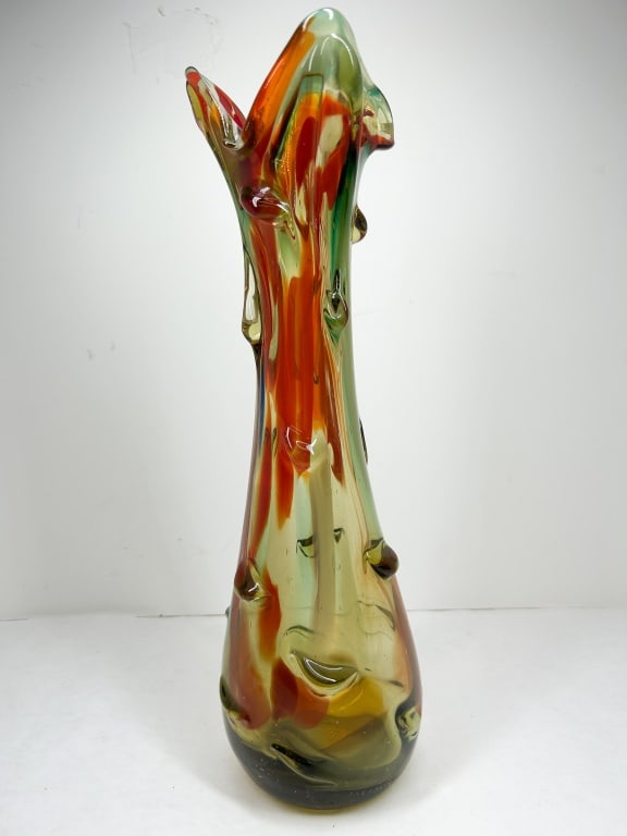 MID-CENTURY MODERN ART GLASS VASE: A tall, free-form hand-blown glass vase featuring a tri-lobed rim and applied decorative nibs along the tapering neck. The polychrome design incorporates orange, green, and amber swirls within a clear