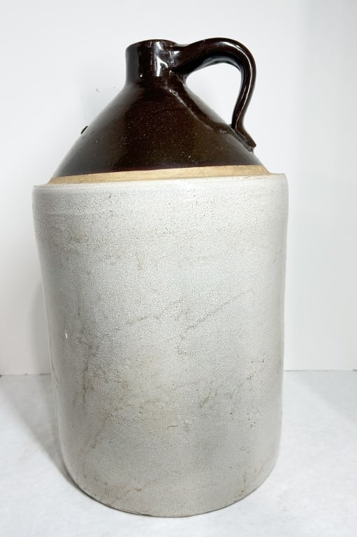 ROBINSON-RANSBOTTOM STONEWARE FIVE-GALLON JUG: A large two-tone stoneware jug produced by the Robinson-Ransbottom Pottery Company of Roseville, Ohio. The vessel features a cylindrical body with a Bristol glaze and a sloped shoulder finished in a d