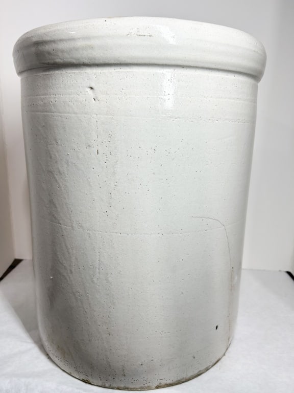 LARGE STONEWARE CYLINDRICAL STORAGE CROCK: A large utilitarian storage crock featuring a cylindrical form with a thick, rounded rim and finished in a light gray Bristol glaze. The upper body displays faint cobalt blue markings, including a hor