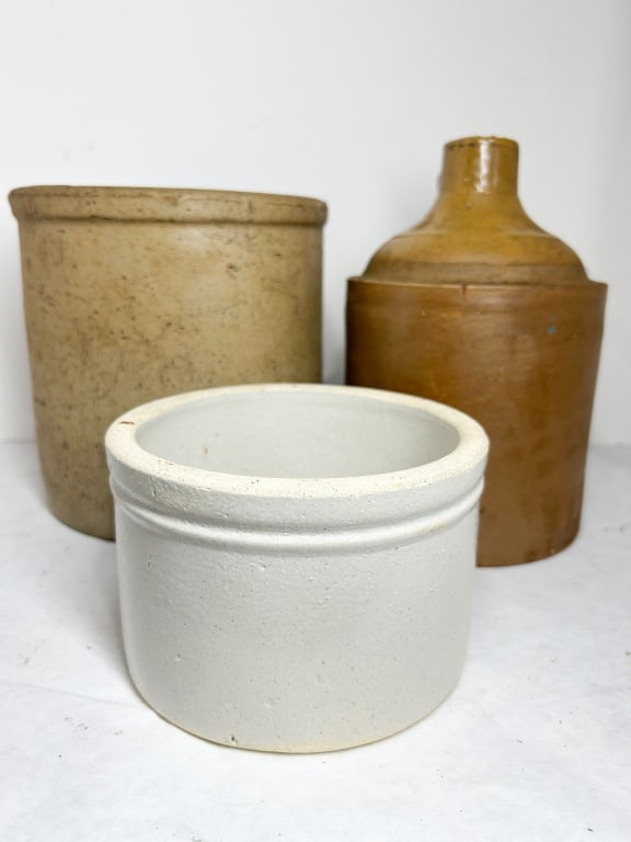 THREE AMERICAN STONEWARE UTILITY VESSELS: A trio of American salt-glazed stoneware storage vessels consisting of a large cylindrical crock with an Albany-type slip glazed interior, a two-tone shouldered jug with an applied loop handle, and a 