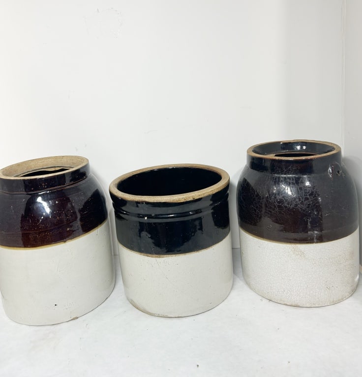 THREE AMERICAN TWO-TONE STONEWARE VESSELS: Three American utilitarian stoneware vessels featuring a dark brown Albany-type slip glaze on the upper portions and a cream Bristol glaze on the lower bodies. The group includes two cylindrical prese