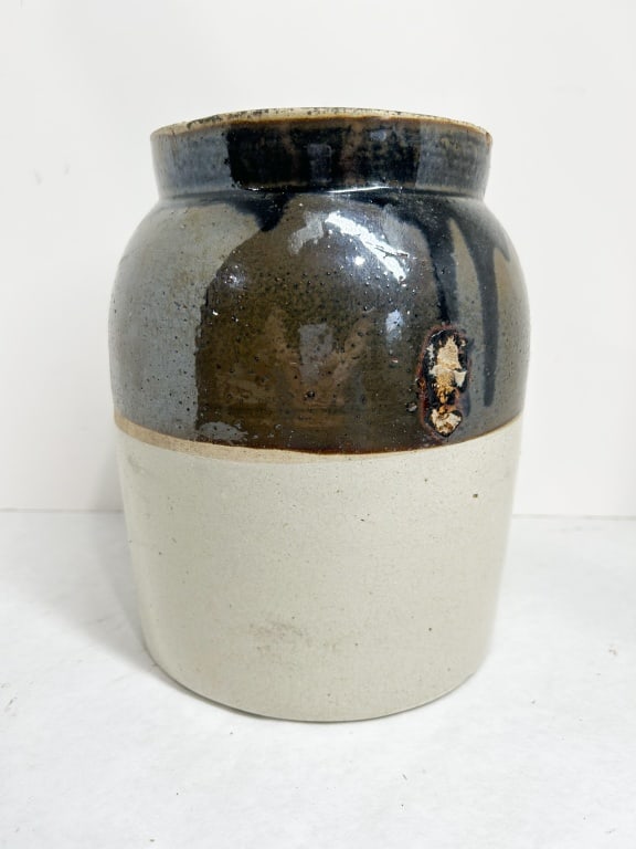 TWO-TONE STONEWARE STORAGE JAR WITH LID: American two-tone salt-glazed stoneware storage jar with an inset lid. The vessel features a cylindrical body with a dark brown glaze on the upper section and a natural cream-colored lower body, with 