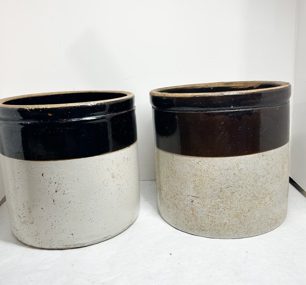 TWO ROBINSON RANSBOTTOM STONEWARE CROCKS: A pair of two-gallon cylindrical stoneware crocks with two-tone glazes. One crock features a stamped black mark depicting a crown with the number "2" inside a central circle; the other features a coba