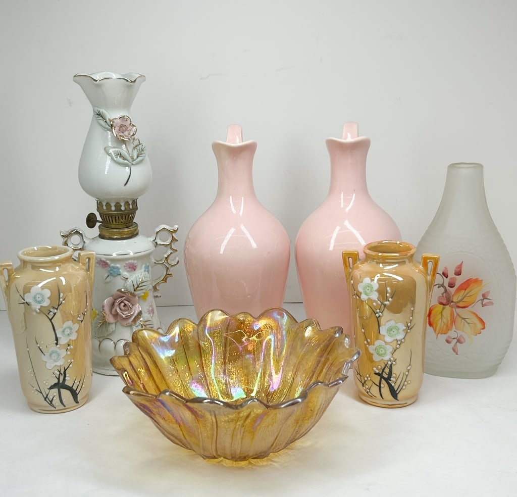 ASSORTMENT OF VINTAGE DECORATIVE CERAMICS AND GLASSWARE: A collection of vintage decorative objects including a pair of porcelain vases, a carnival glass bowl, a frosted glass bottle, a porcelain miniature oil lamp, and two ceramic pitchers. The pair of lus