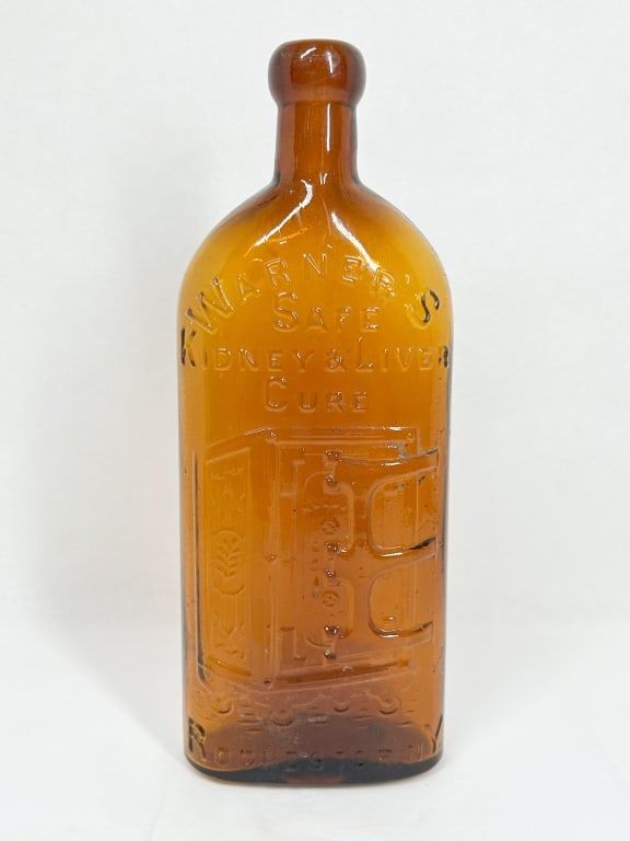 WARNER'S AMBER GLASS MEDICINE BOTTLE: A late 19th-century amber glass patent medicine bottle for Warner's Safe Kidney & Liver Cure. The front is embossed with curved and horizontal text reading WARNER'S / SAFE / KIDNEY & LIVER / CURE abov