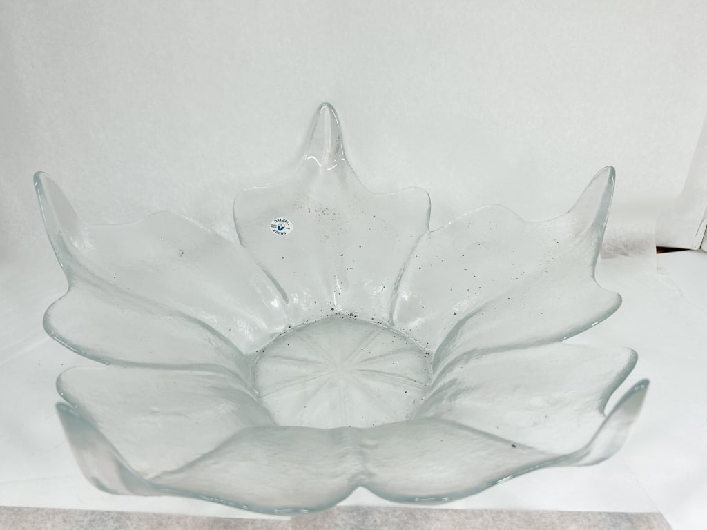 DALZELL-VIKING CLEAR GLASS LOTUS BOWL: A Dalzell-Viking glass centerpiece bowl in a stylized eight-petal floral form. A circular white adhesive label on the interior of one petal reads DALZELL in an arc above a stylized bird logo and