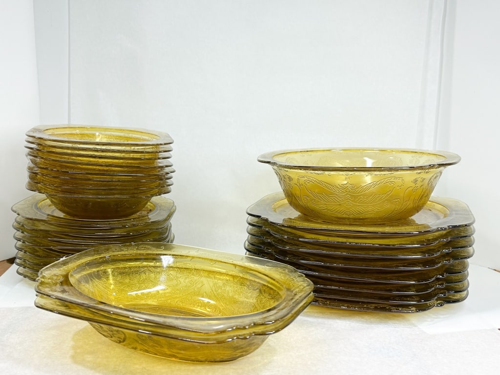 FEDERAL MADRID AMBER GLASS TABLEWARE: A collection of amber pressed glass dinnerware in the Madrid pattern produced by the Federal Glass Company. The set includes square dinner plates with scalloped corners, circular bowls, an oval