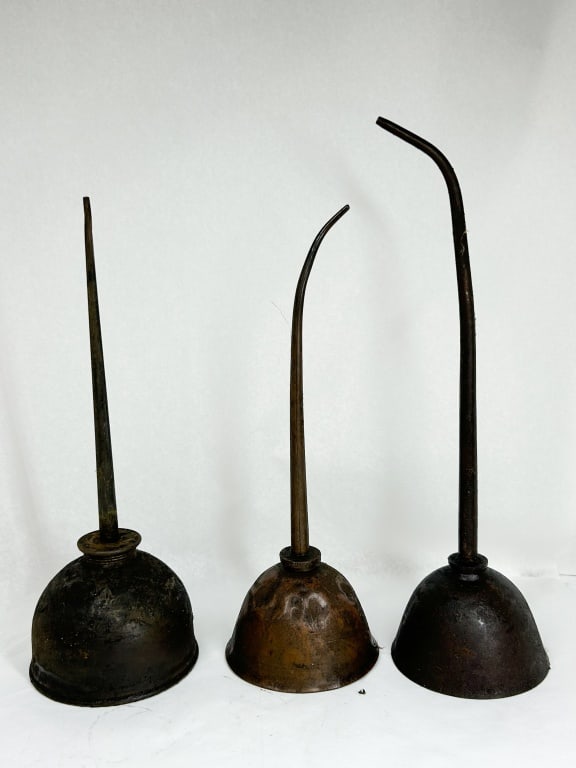 GEM MFG CO THREE STEEL OILERS: A trio of vintage industrial thumb-pump oilers featuring tapered spouts and spring-metal bases. One unit bears an impressed circular mark on the body reading GEM MFG CO PITTSBURGH PA around a central