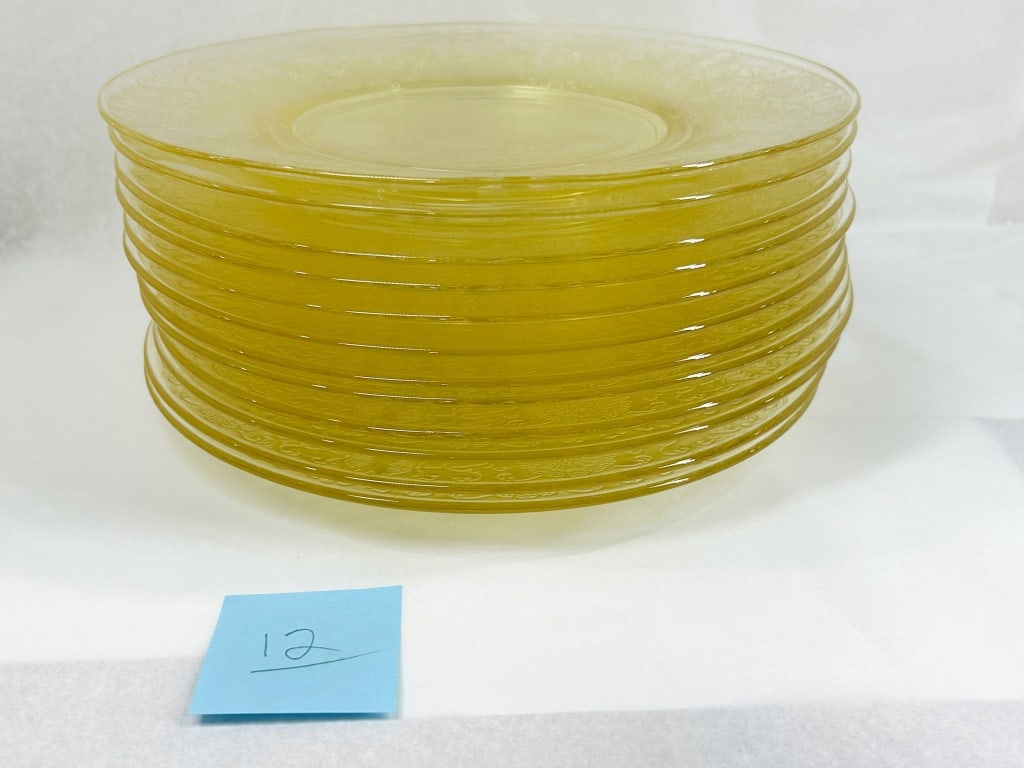 SET OF TWELVE YELLOW DEPRESSION GLASS PLATES: A set of twelve yellow glass plates featuring the Sharon pattern, also known as Cabbage Rose. The design consists of a mold-etched floral border with roses and scrolls and a matching central medallion