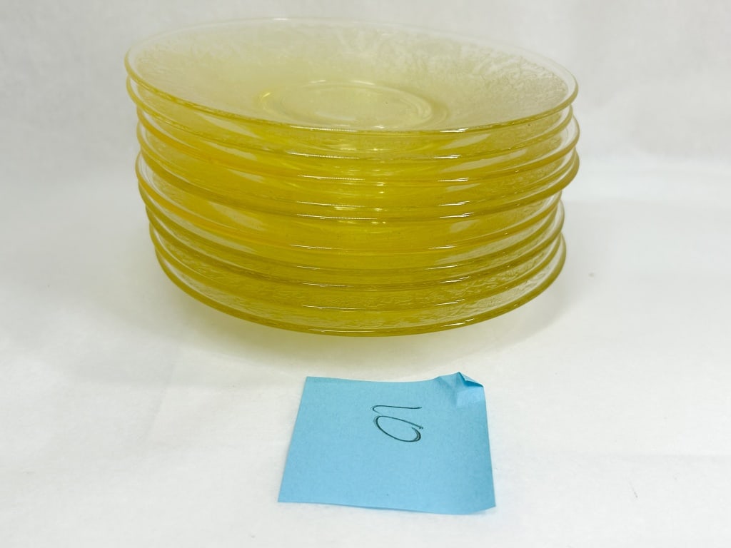 SET OF TEN YELLOW DEPRESSION GLASS SAUCERS: A set of ten yellow translucent glass saucers featuring an all-over etched floral and scroll motif. The pattern is consistent with the Lorain design produced by Indiana Glass Company, characterized by