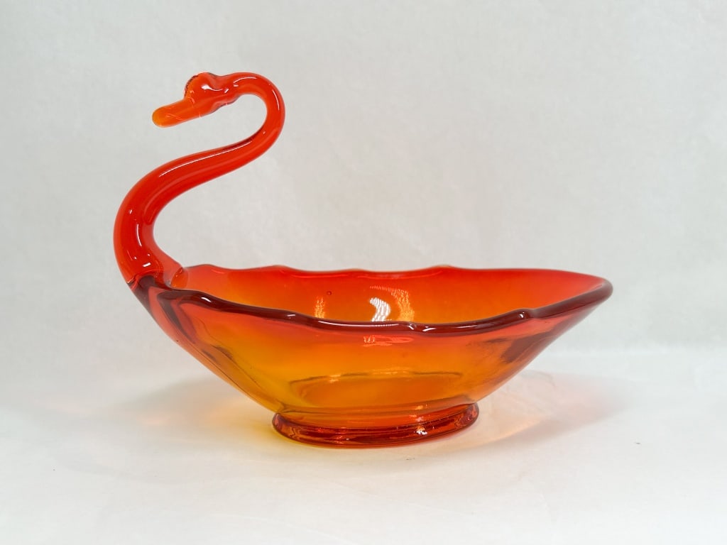 AMBERINA ART GLASS SWAN BOWL, MID-20TH CENTURY: A mid-century modern art glass swan bowl featuring a cadmium amberina ombr? effect transitioning from fiery red to golden orange. The piece is constructed with a mold-blown body and a hand-stretched s