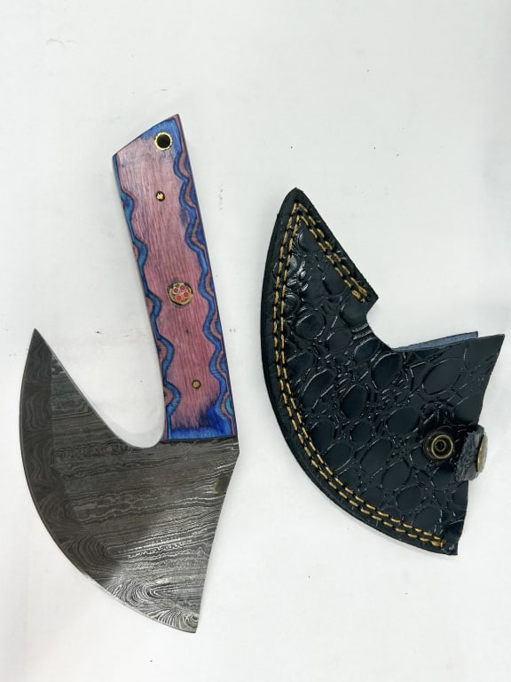 DAMASCUS STEEL ULU STYLE HATCHET: A custom fixed-blade ulu style hatchet featuring a pattern-welded Damascus steel blade and full-tang construction. The handle consists of dyed multi-tonal wood scales in purple and blue, secured by br