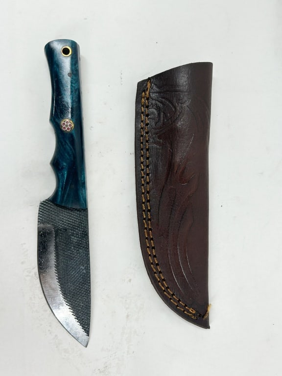 DAMASCUS FULL TANG FILE KNIFE: A custom fixed-blade hunting knife crafted from a repurposed cross-cut metal file with mottled teal composite handle scales. The full tang construction is secured by two brass pins and a decorative fl