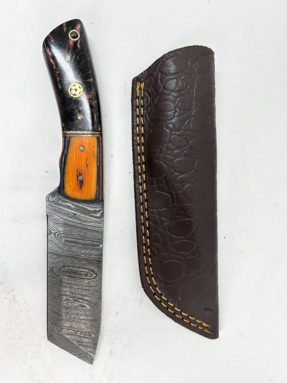 CUSTOM DAMASCUS STEEL FIXED BLADE KNIFE: A custom fixed-blade utility knife featuring a pattern-welded Damascus steel blade with a clip point. The handle is constructed with a decorative bolster of stabilized burl resin and a secondary secti
