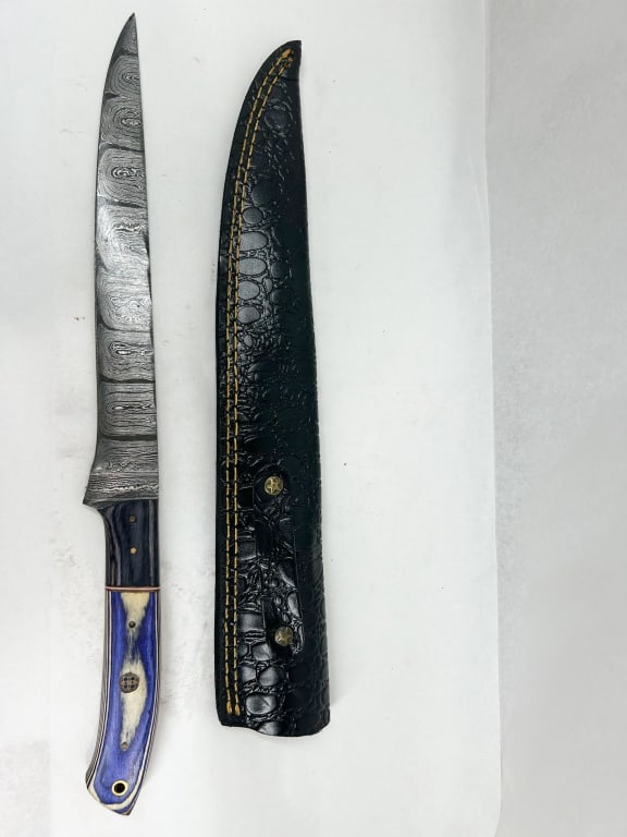 DAMASCUS STEEL FILLET KNIFE AND SHEATH: A modern fixed-blade fillet knife featuring a pattern-welded Damascus steel blade and a full tang with decorative file-work. The handle is constructed with dark wood and blue dyed bone scales secured 