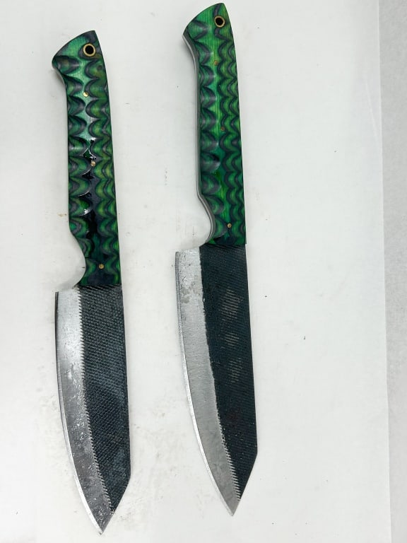DAMASCUS PAIR OF CUSTOM HANDMADE STEEL FILE KNIVES: A pair of fixed-blade utility knives handcrafted from repurposed high carbon steel industrial files, featuring full tang construction. The blades retain original cross-cut file textures on the flats, 