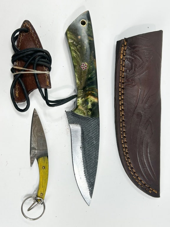 DAMASCUS TWO STEEL UTILITY KNIVES AND SHEATHS: A custom fixed-blade utility knife crafted from a repurposed steel file, featuring a stabilized burl and resin composite handle with a decorative floral mosaic pin and brass lanyard tube. Included is 
