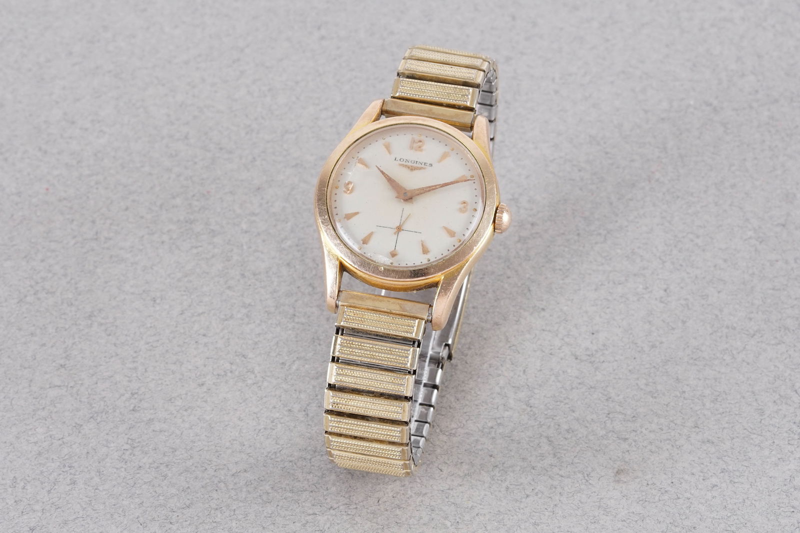 LONGINES GOLD FILLED WRISTWATCH: LONGINES GOLD FILLED WRISTWATCH, this watch is fitted with a circular off white dial with applied gold arabic numeral and arrow head hour markers and hands. The 33mm case is fitted with a crown and a