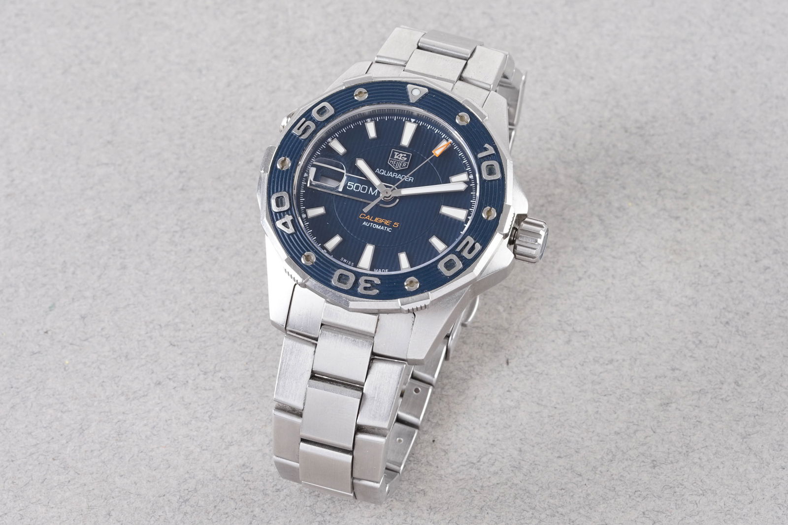 TAG HEUER AQUARACER CALIBRE 5 AUTOMATIC DATE REF. WAJ2112: TAG HEUER AQUARACER CALIBRE 5 AUTOMATIC DATE REF. WAJ2112, this watch is a ref. WAJ2112 and is fitted with a circular textured blue dial with hour markers and hands. The 43mm stainless steel case is