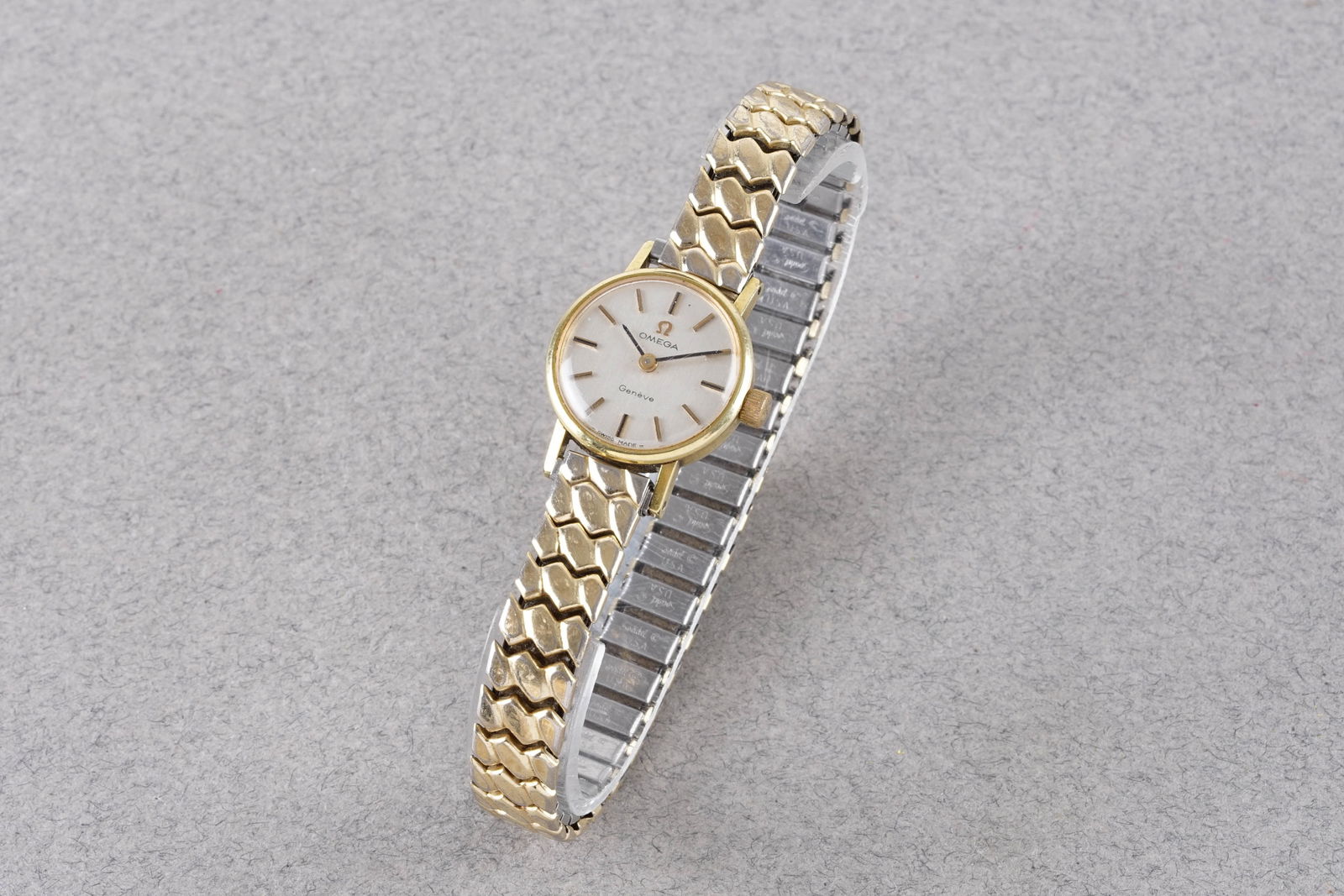 OMEGA GENEVE GOLD PLATED WRISTWATCH: OMEGA GENEVE GOLD PLATED WRISTWATCH, this watch is fitted with a circular silver dial with applied stick hour markers and hands. The 20mm gold plated case is fitted with a crown and a case back.