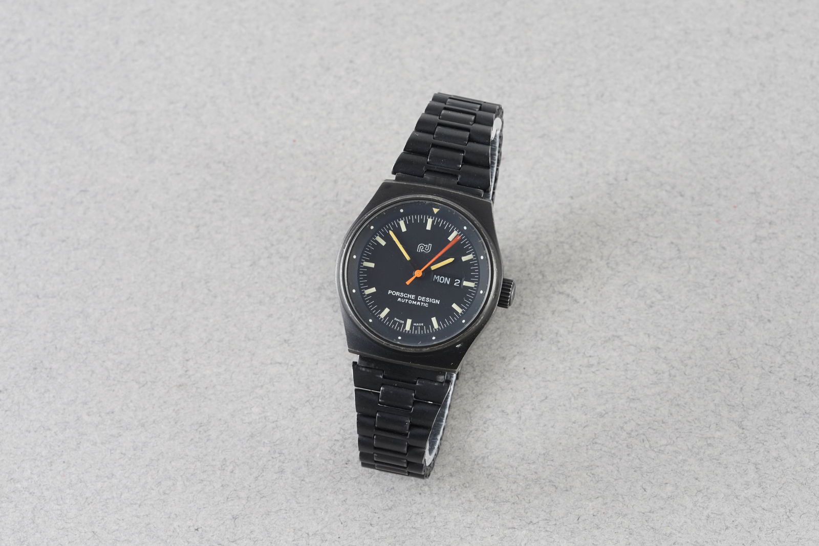 PORSCHE DESIGN AUTOMATIC DAY DATE VINTAGE WRISTWATCH: PORSCHE DESIGN AUTOMATIC DAY DATE VINTAGE WRISTWATCH, this watch is fitted with a circular black dial with hour markers and hands. The 30mm PVD case is fitted with a crown and a case back. Inside is