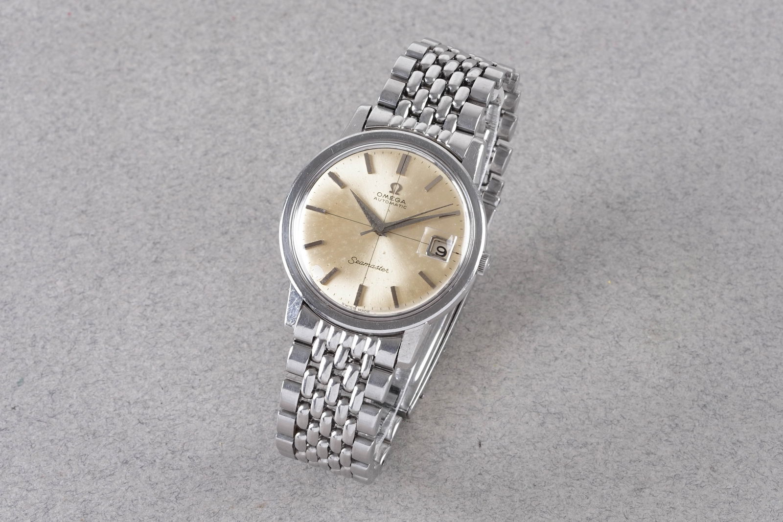 OMEGA SEAMASTER DATE SECTOR DIAL AUTOMATIC WRISTWATCH: OMEGA SEAMASTER DATE SECTOR DIAL AUTOMATIC WRISTWATCH, this watch is fitted with a circular patina sector dial with a date window, hour markers and hands. The 35mm stainless steel case is fitted with