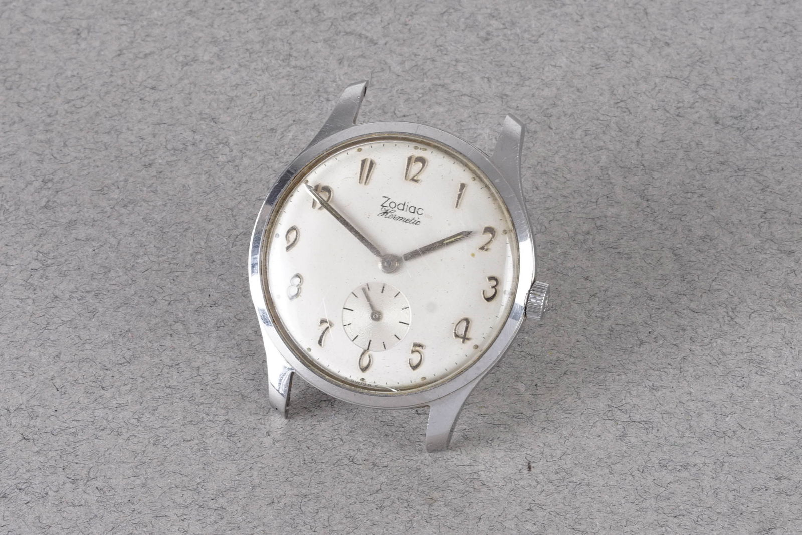 ZODIAC HERMETIC WRISTWATCH: ZODIAC HERMETIC WRISTWATCH, this watch is fitted with a circular off white dial with applied arabic numeral hour markers and hands. The 34mm stainless steel case is fitted with a crown and a case