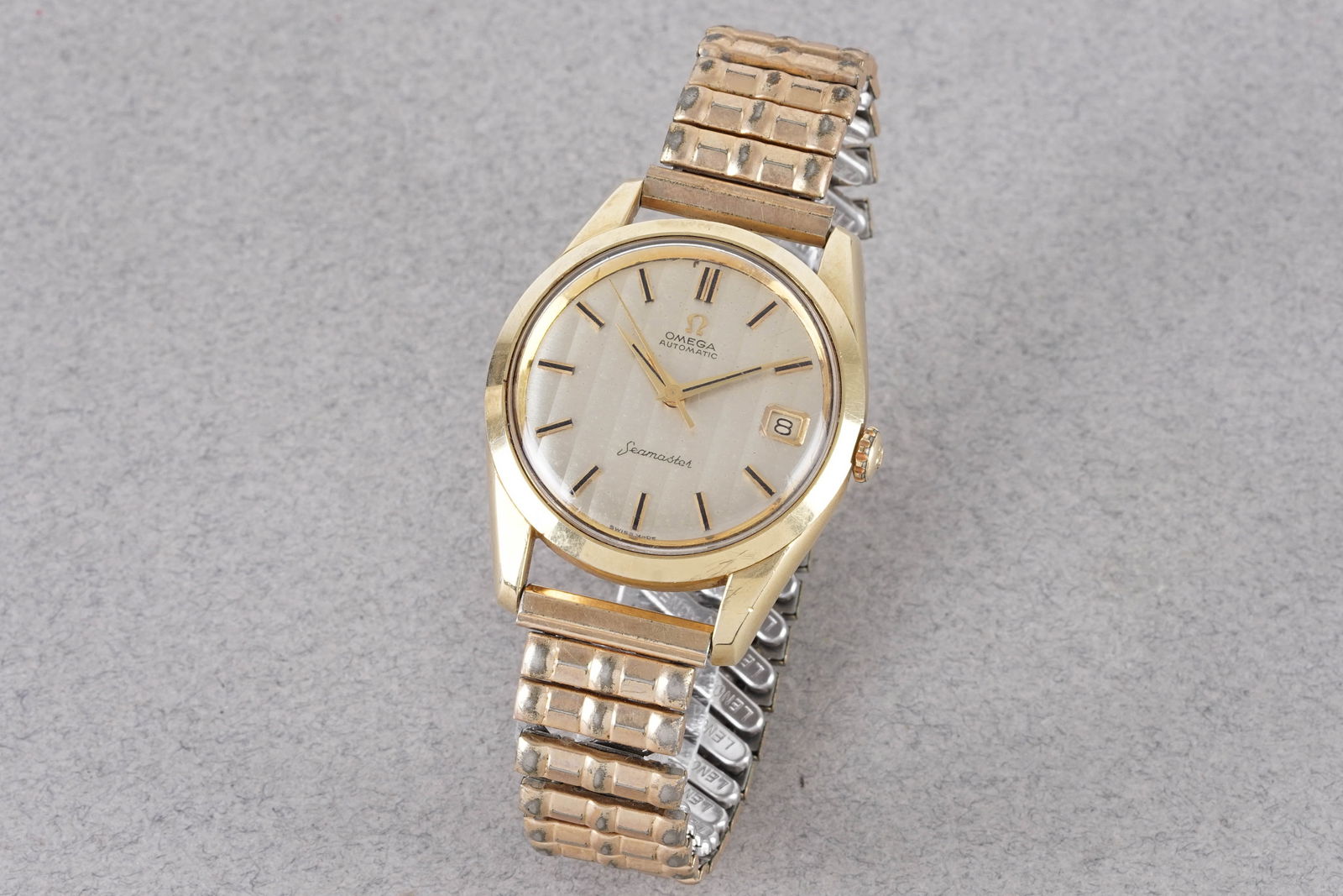 OMEGA SEAMASTER TAPESTRY DIAL GOLD PLATED WRISTWATCH: OMEGA SEAMASTER TAPESTRY DIAL GOLD PLATED WRISTWATCH, this watch is fitted with a circular silver tapestry dial with a date window, applied stick hour markers and hands. The 35mm gold plated case is