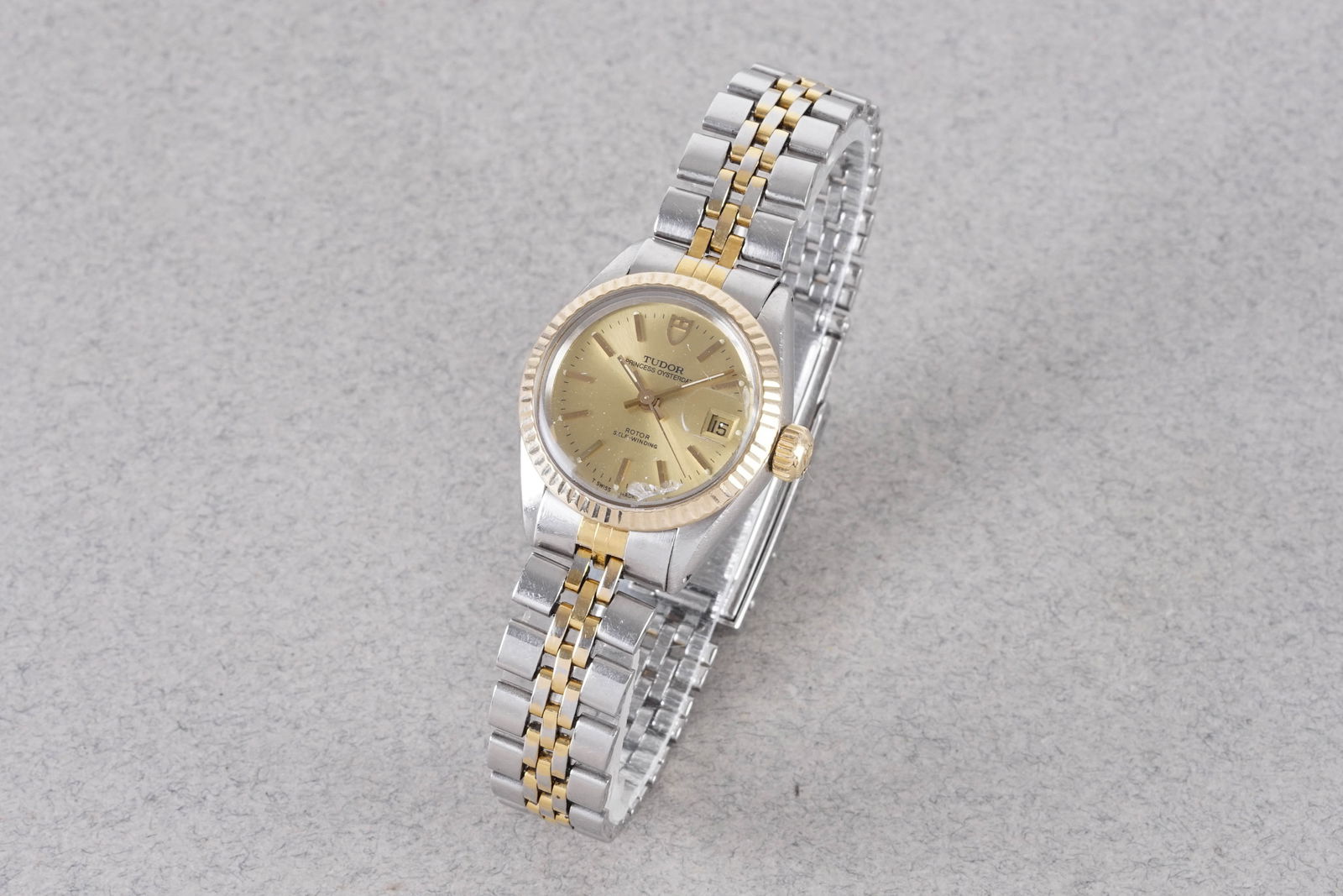 TUDOR PRINCESS OYSTERDATE AUTOMATIC WRISTWATCH: TUDOR PRINCESS OYSTERDATE AUTOMATIC WRISTWATCH, this watch is fitted with a circular champagne dial with a date window, stick hour markers and hands. The 25mm stainless steel and gold case is fitted
